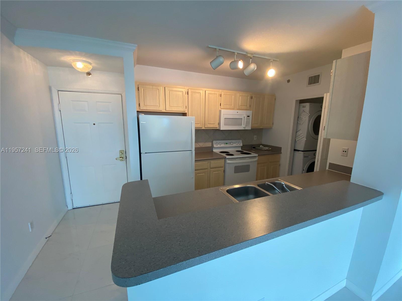2665 Southwest 37th Avenue, Unit 508 Miami, FL 33133 - Photo 3 of 12 a kitchen with refrigerator and white cabinets