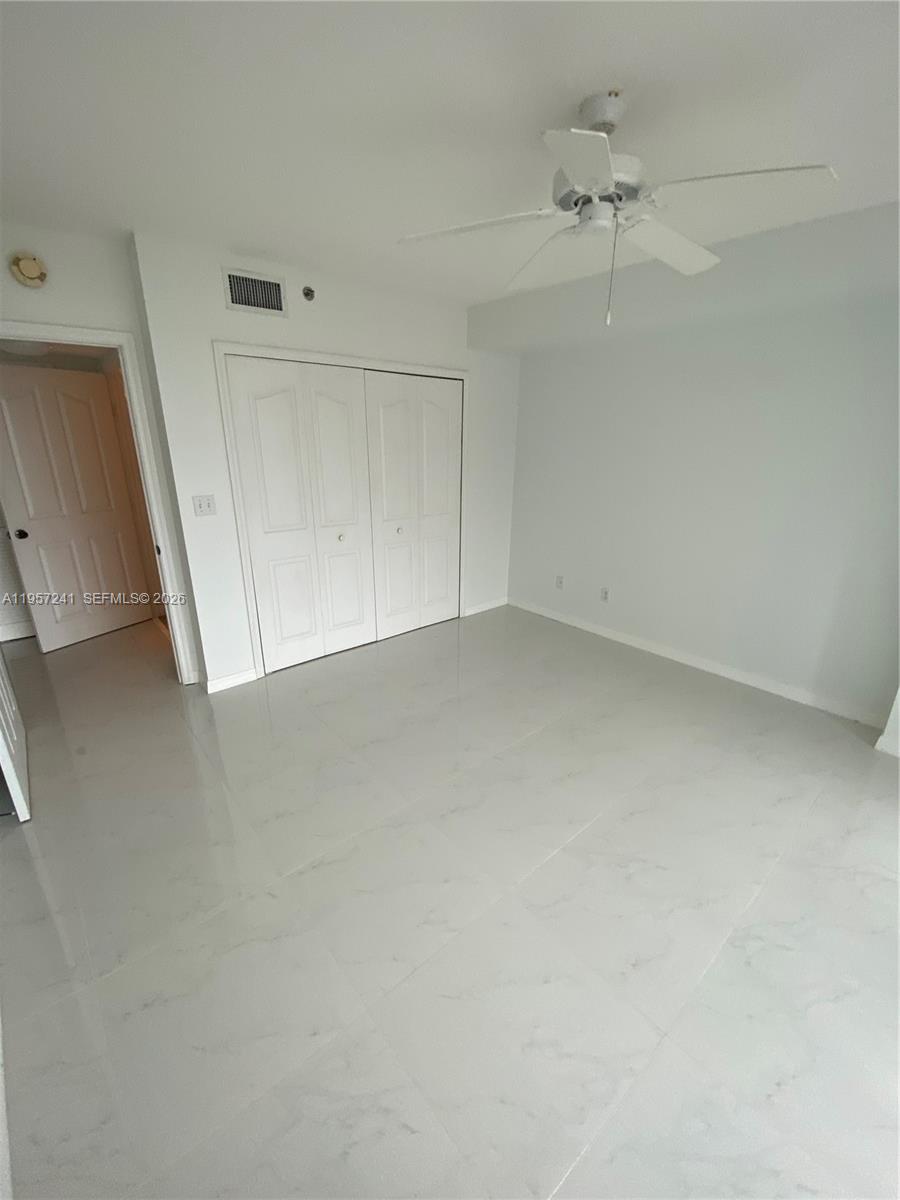 2665 Southwest 37th Avenue, Unit 508 Miami, FL 33133 - Photo 5 of 12 an empty room with a empty space and a ceiling fan