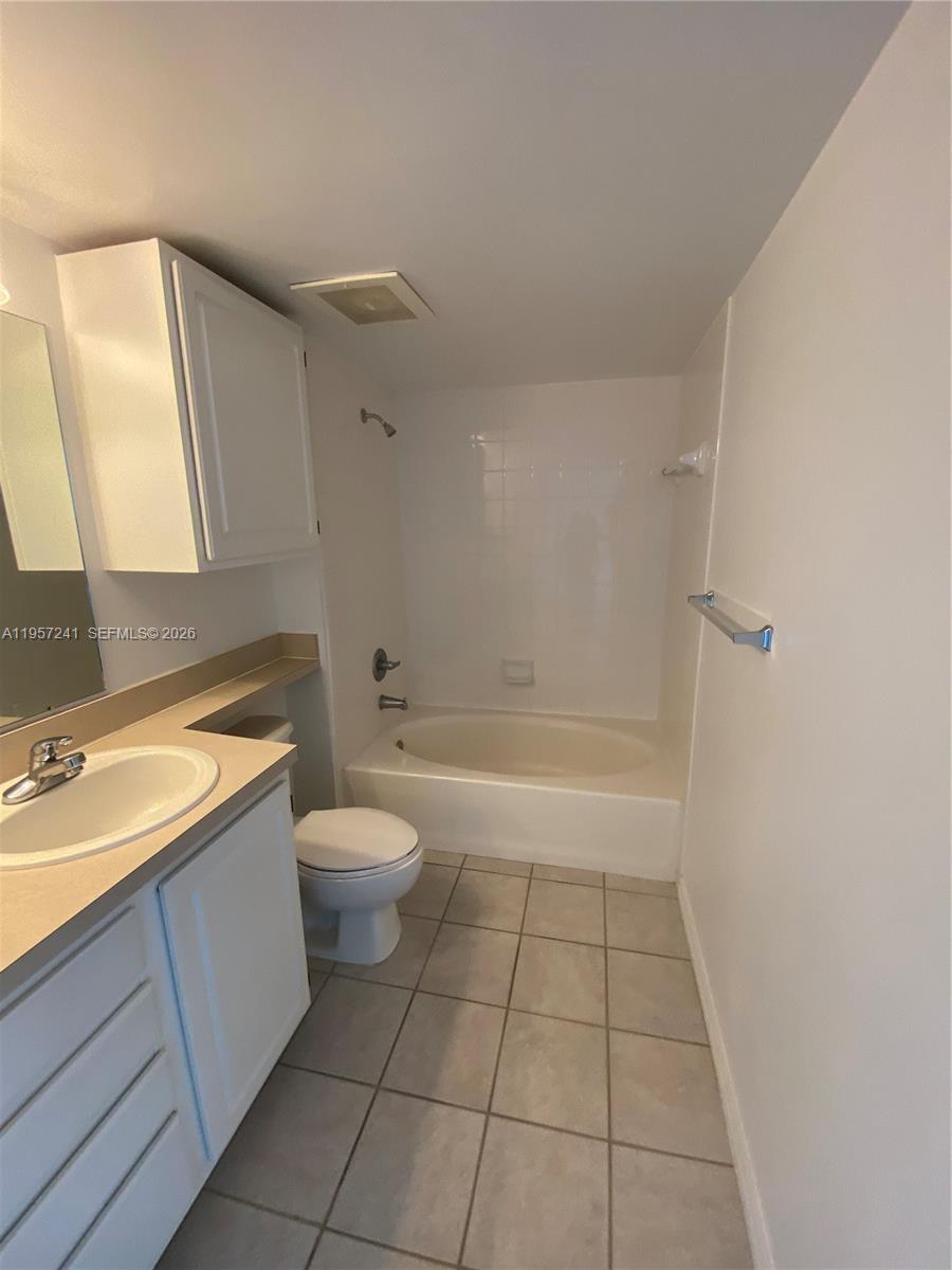 2665 Southwest 37th Avenue, Unit 508 Miami, FL 33133 - Photo 6 of 12 a bathroom with a granite countertop sink toilet a mirror and shower