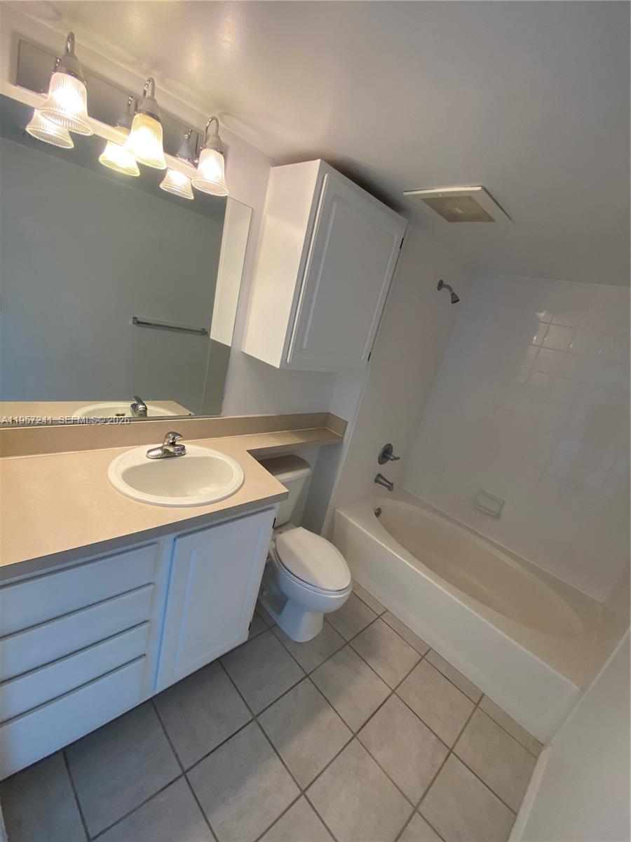 2665 Southwest 37th Avenue, Unit 508 Miami, FL 33133 - Photo 7 of 12 a bathroom with a bathtub sink vanity and toilet