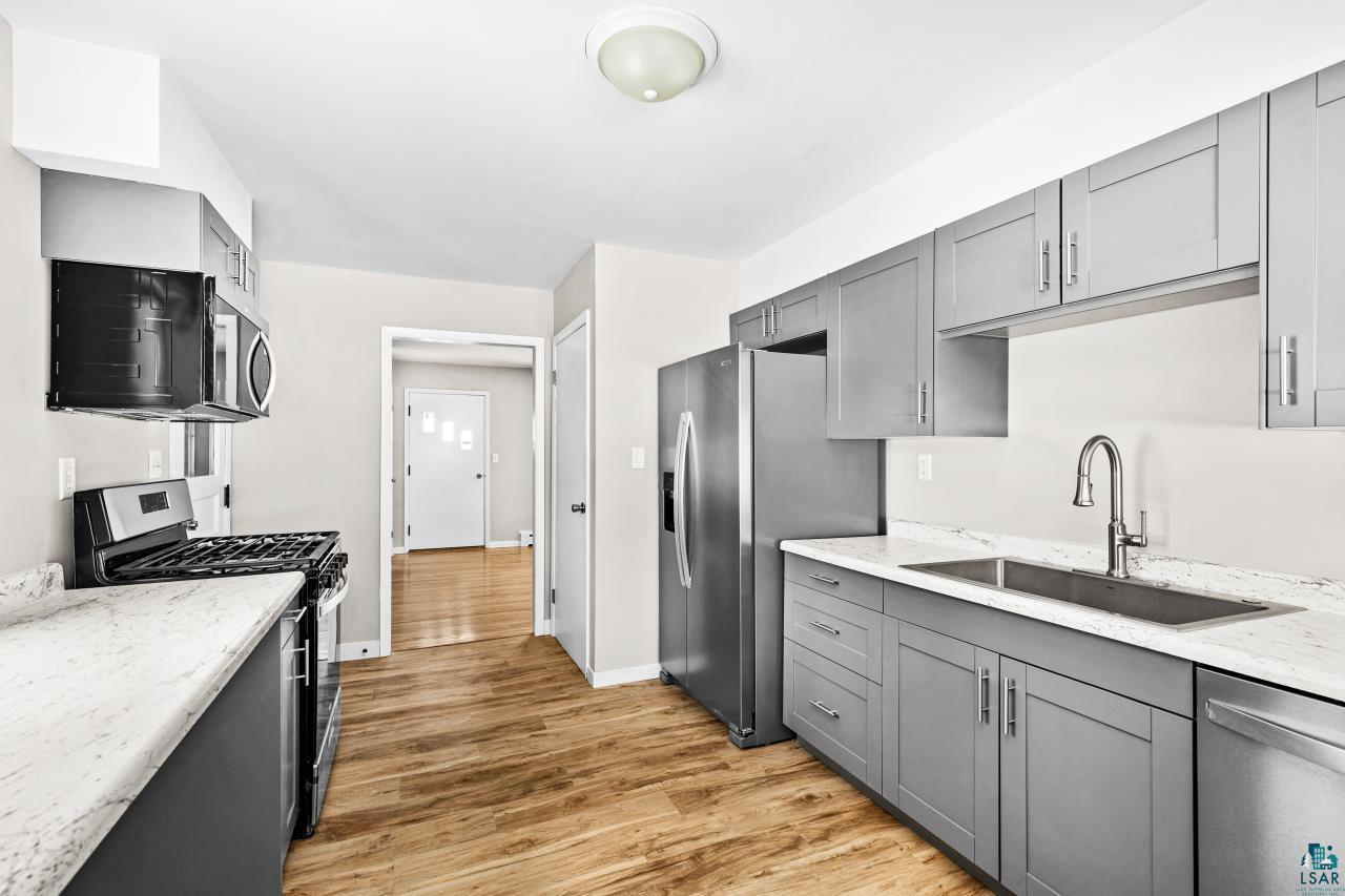 3754 Carlton Street Barnum, MN 55707 - Photo 13 of 52 Kitchen featuring gray cabinetry, light stone counters, stainless steel appliances, and light wood-type flooring