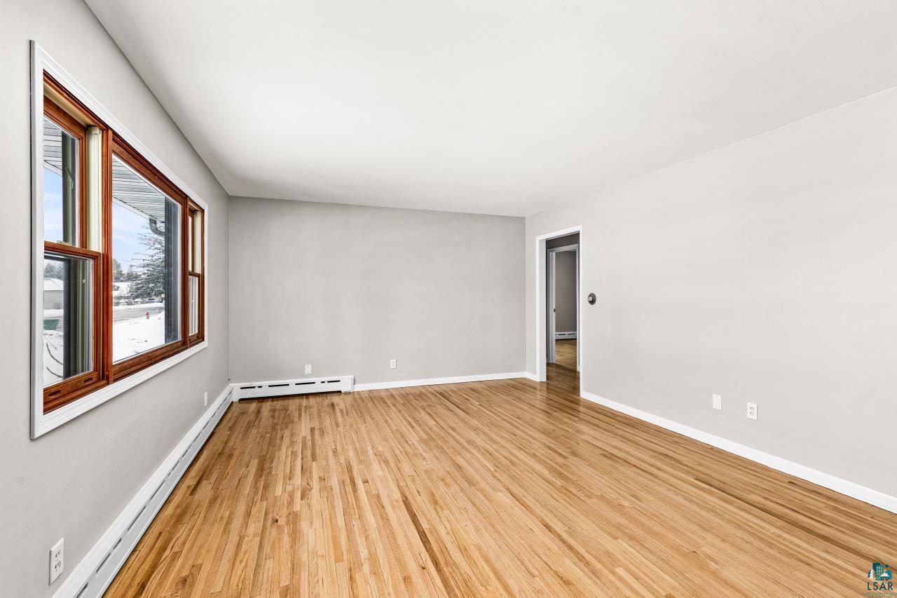 3754 Carlton Street Barnum, MN 55707 - Photo 14 of 52 Spare room with a baseboard heating unit, light wood-type flooring, and baseboard heating