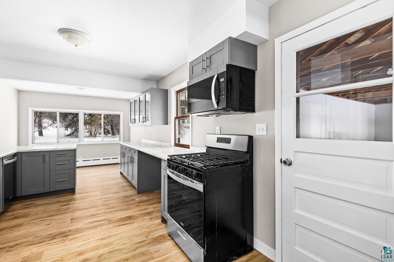 3754 Carlton Street Barnum, MN 55707 - Photo 17 of 52 Kitchen with gray cabinetry, stainless steel appliances, light wood finished floors, and light stone countertops