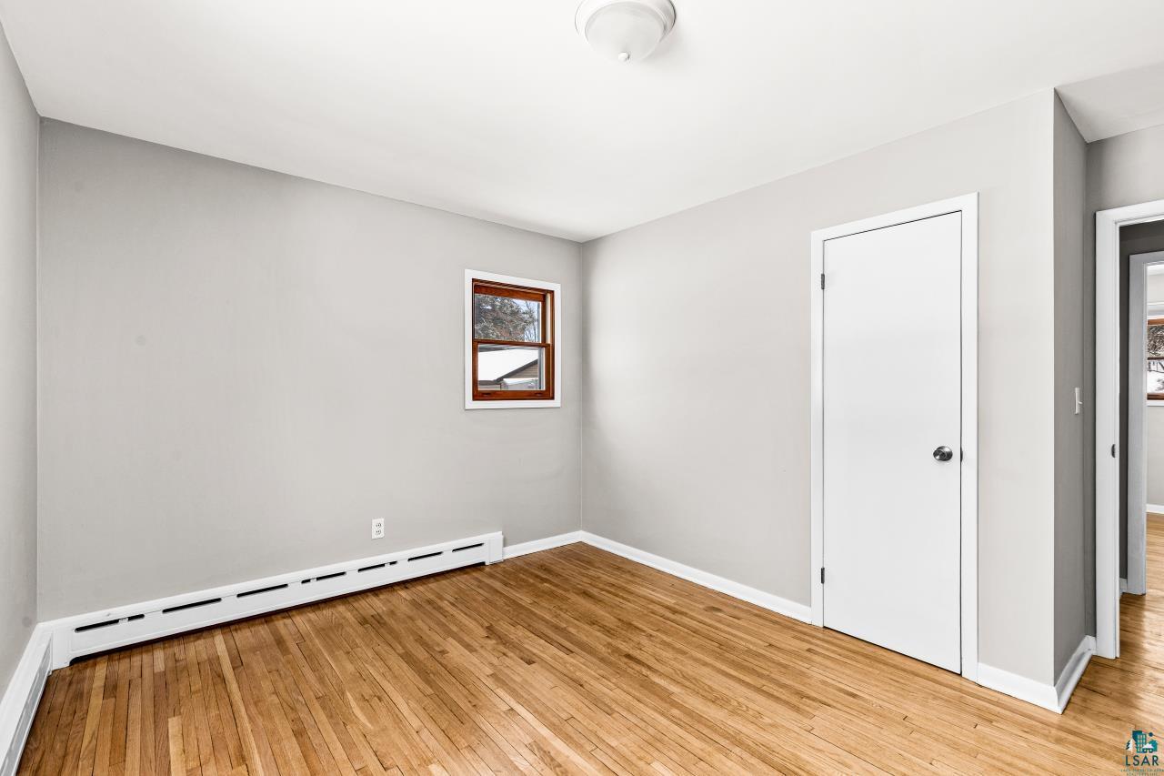 3754 Carlton Street Barnum, MN 55707 - Photo 20 of 52 Unfurnished room featuring a baseboard heating unit and light wood-type flooring