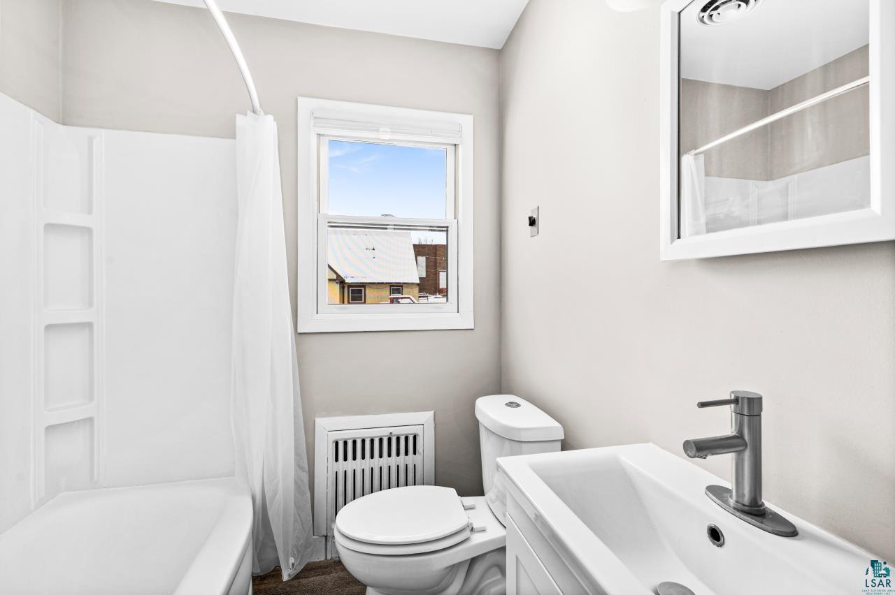 3754 Carlton Street Barnum, MN 55707 - Photo 22 of 52 Full bathroom with vanity, shower / bath combo with shower curtain, and radiator heating unit