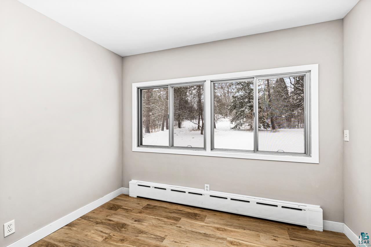 3754 Carlton Street Barnum, MN 55707 - Photo 26 of 52 Unfurnished room with a baseboard heating unit, light wood-style flooring, and plenty of natural light