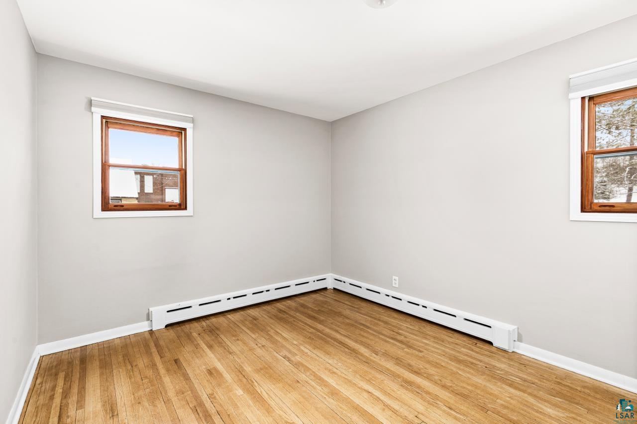 3754 Carlton Street Barnum, MN 55707 - Photo 40 of 52 Empty room with light wood-style flooring, healthy amount of natural light, and a baseboard heating unit