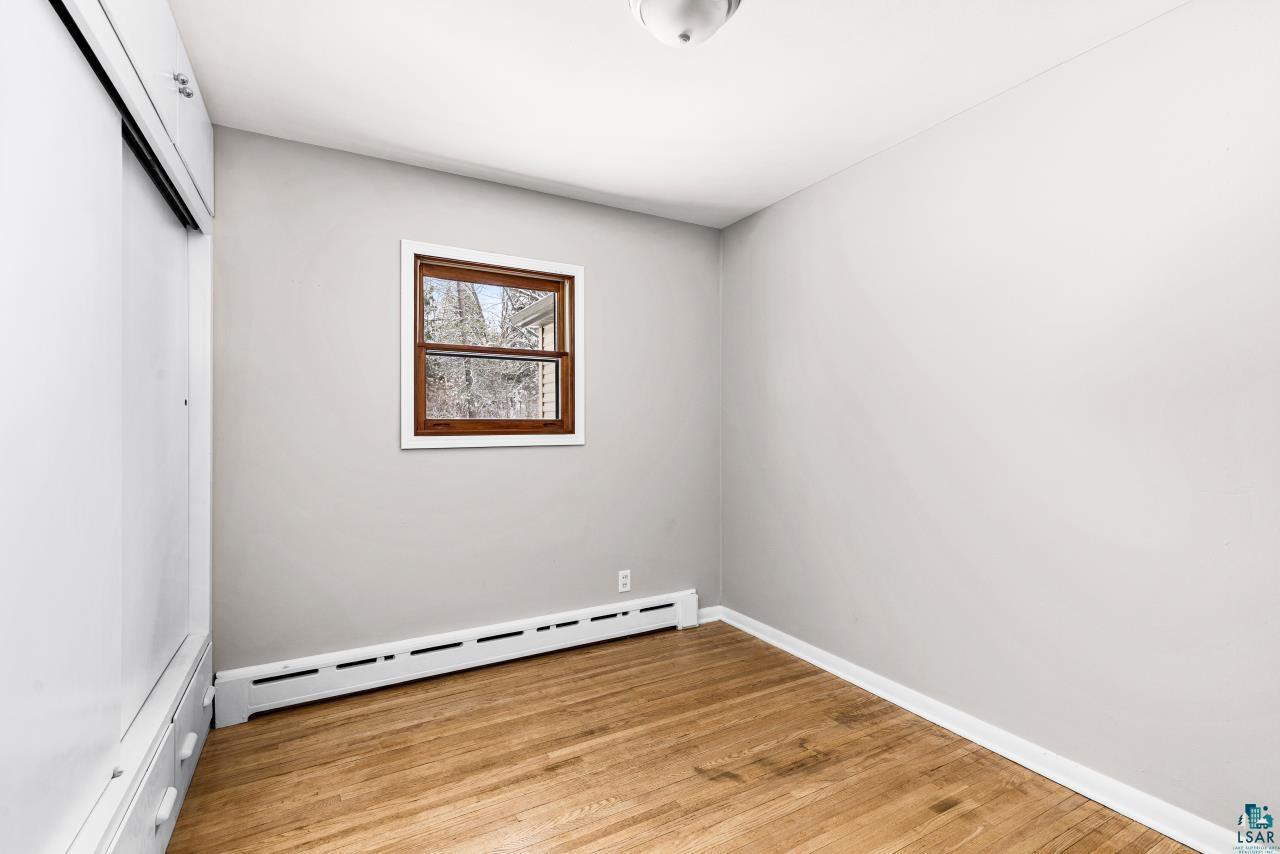 3754 Carlton Street Barnum, MN 55707 - Photo 41 of 52 Unfurnished bedroom featuring a baseboard heating unit, light wood-style floors, and a closet