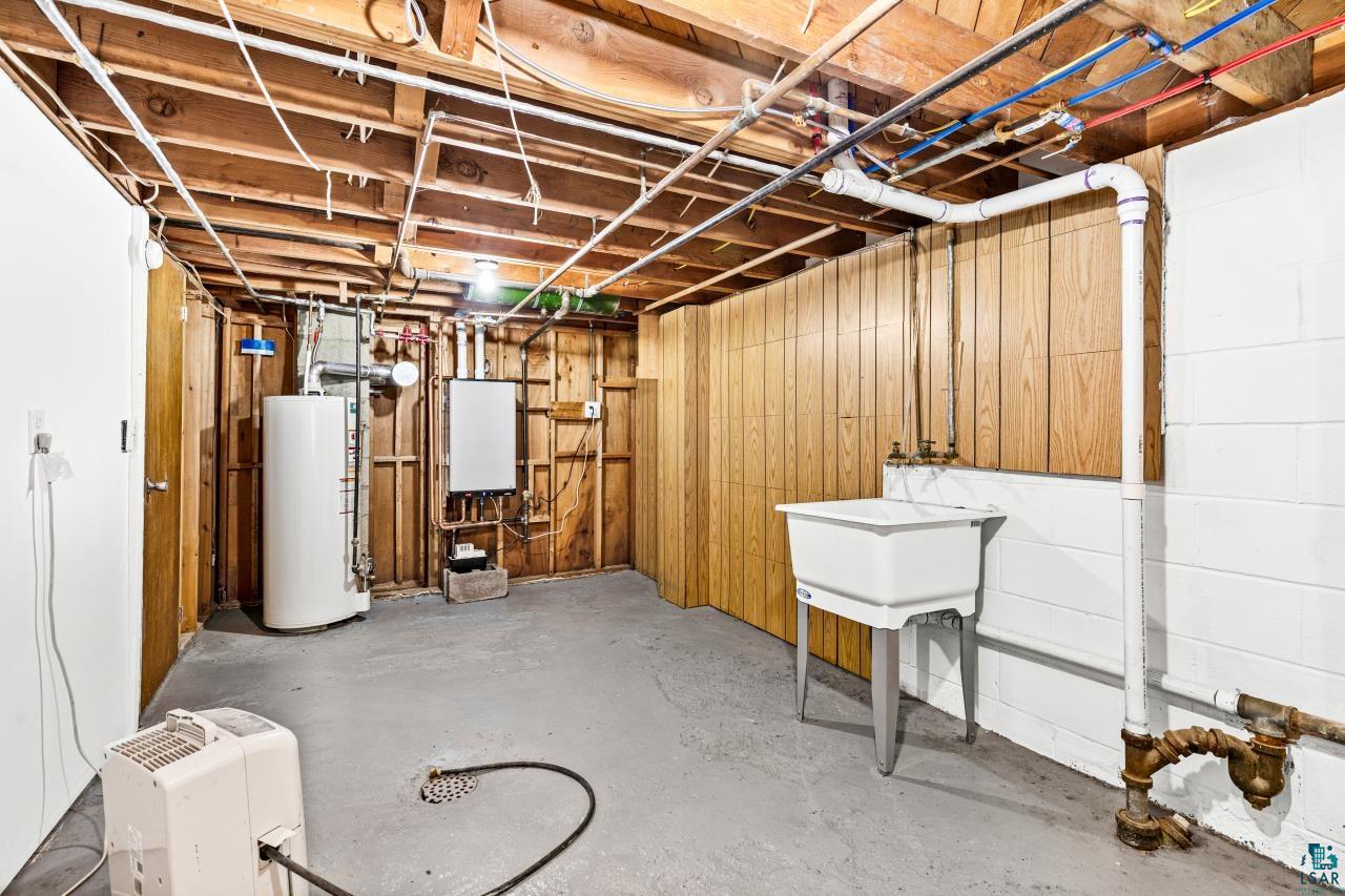 3754 Carlton Street Barnum, MN 55707 - Photo 50 of 52 Unfinished basement with gas water heater, wooden walls, and a heating unit