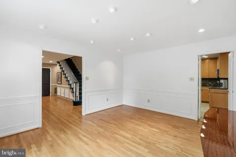 a view of a hallway with wooden floor and a bathroom