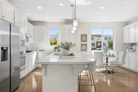 a kitchen with stainless steel appliances kitchen island granite countertop a sink and refrigerator
