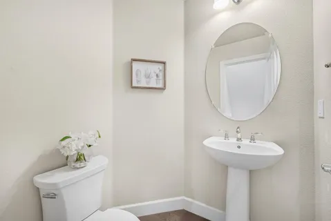 a bathroom with a sink toilet and a mirror