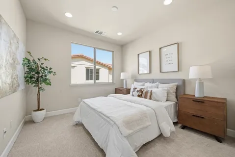 a spacious bedroom with a bed and a potted plant