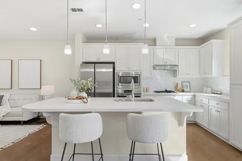 a kitchen with stainless steel appliances kitchen island granite countertop a kitchen island a stove and a cabinets