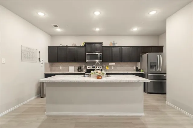 a living room with furniture a flat screen tv and kitchen view