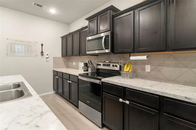 a kitchen with stainless steel appliances granite countertop a sink stove and refrigerator