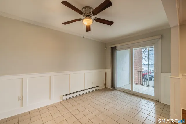 a view of an empty room and window with a ceiling fan