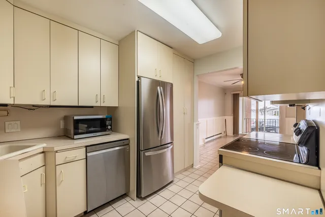 a kitchen with a refrigerator a stove top oven and cabinets