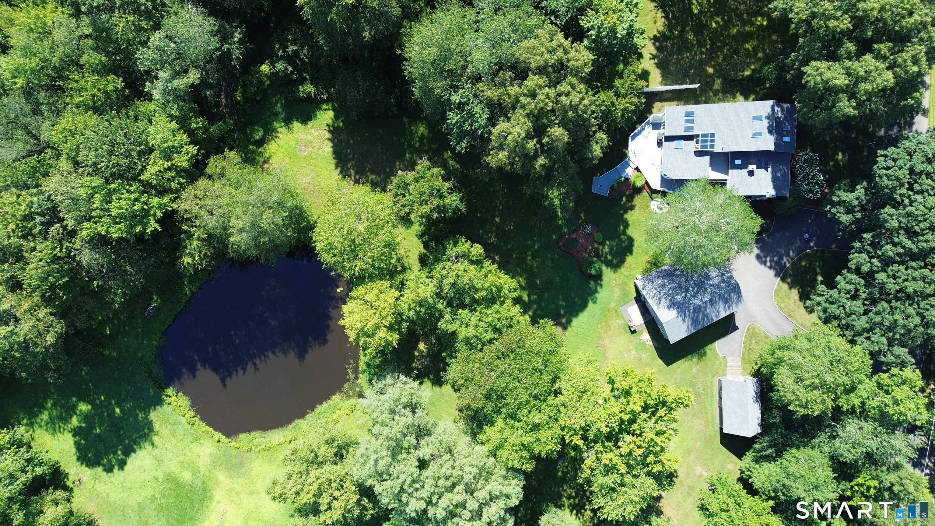 Arial view of property - pond, house, garage & outbuilding