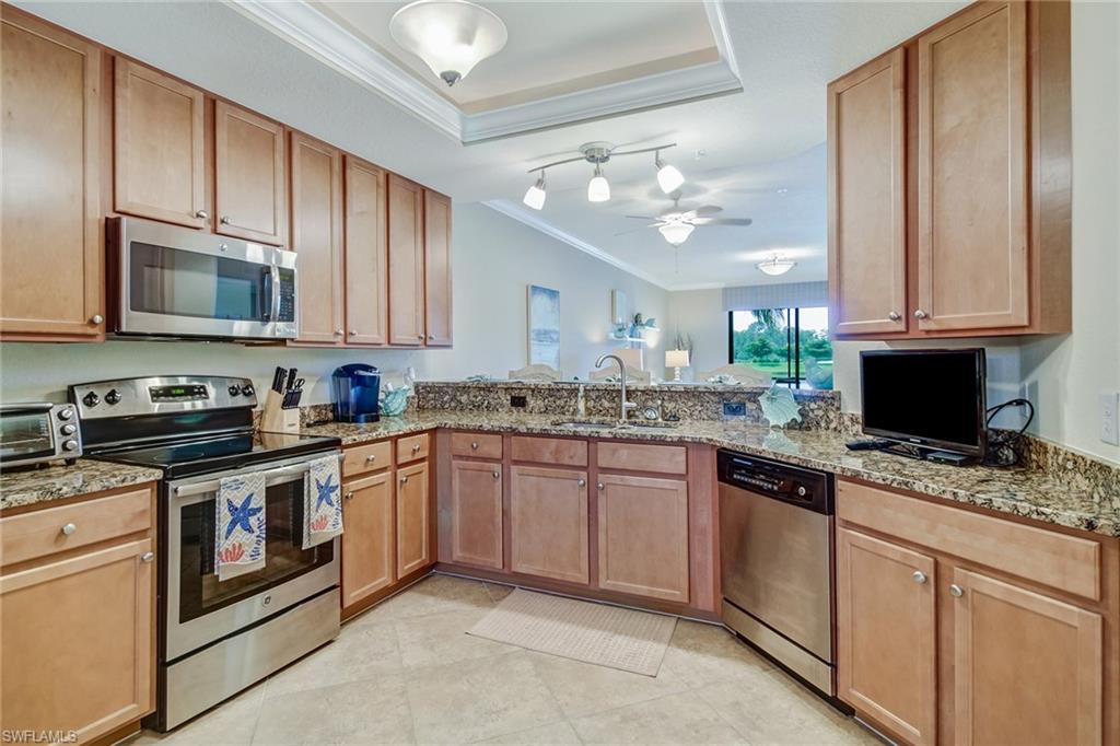 9514 Avellino Way, Unit 2116 Naples, FL 34113 - Photo 11 of 30 a kitchen with granite countertop a sink stainless steel appliances and cabinets