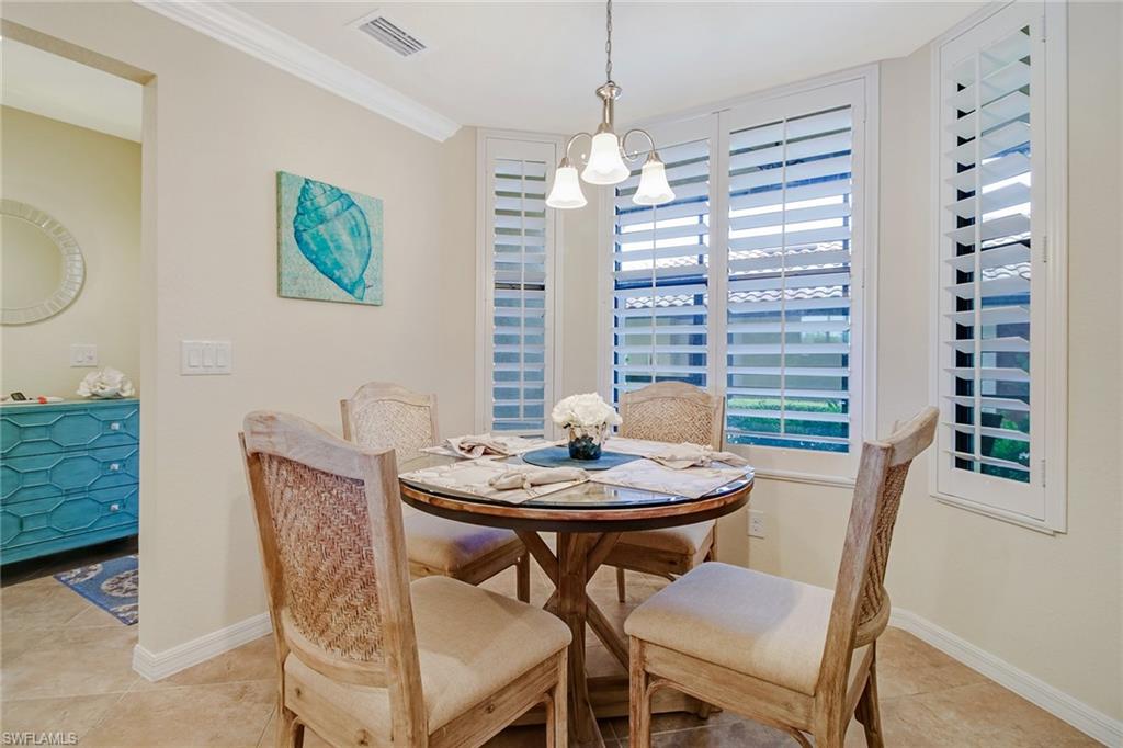 9514 Avellino Way, Unit 2116 Naples, FL 34113 - Photo 12 of 30 a view of a dining room with furniture window and wooden floor