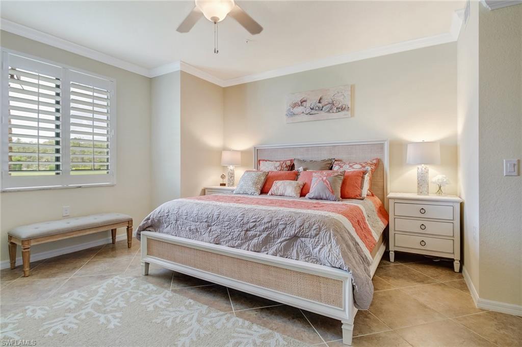 9514 Avellino Way, Unit 2116 Naples, FL 34113 - Photo 14 of 30 a spacious bedroom with a bed and a chandelier