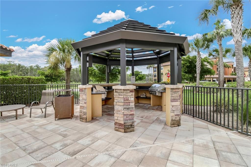 9514 Avellino Way, Unit 2116 Naples, FL 34113 - Photo 24 of 30 a view of a patio with a table and chairs