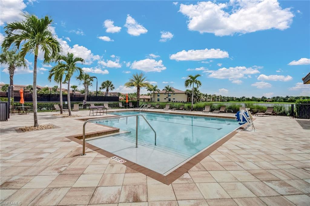 9514 Avellino Way, Unit 2116 Naples, FL 34113 - Photo 25 of 30 a view of a swimming pool with a lounge chair and palm trees