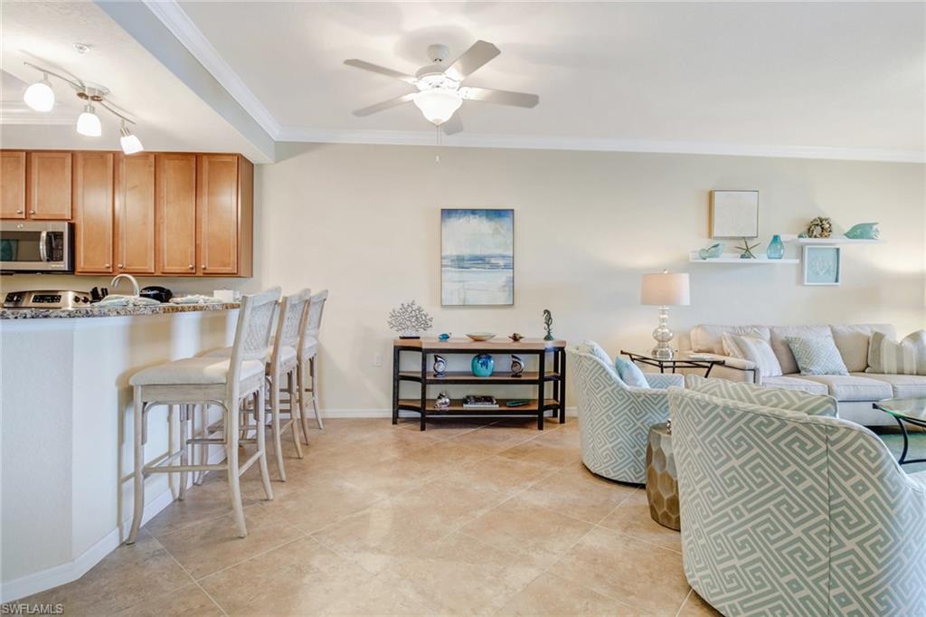 9514 Avellino Way, Unit 2116 Naples, FL 34113 - Photo 8 of 30 a bedroom with furniture and a chandelier