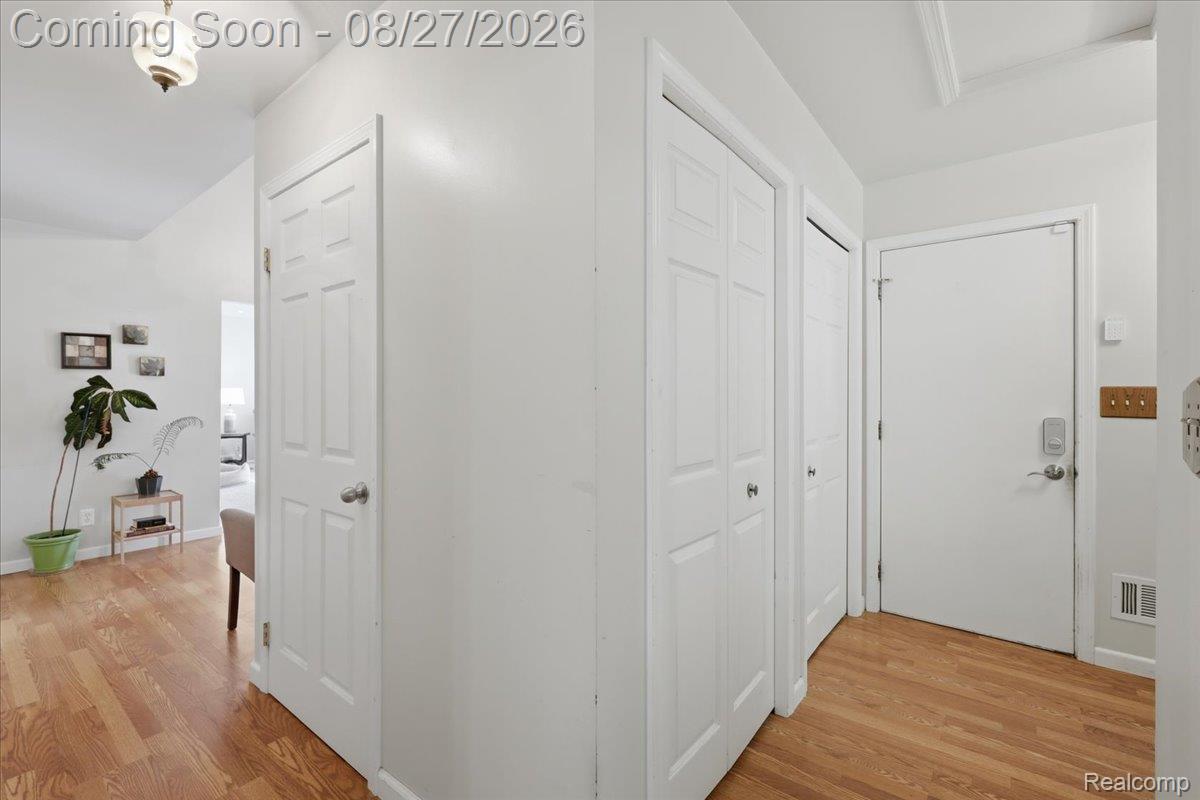 10100 Springtime Circle Clarkston, MI 48348 - Photo 30 of 73 Wood-finish flooring, white paneled doors, and a decorative ceiling light fixture