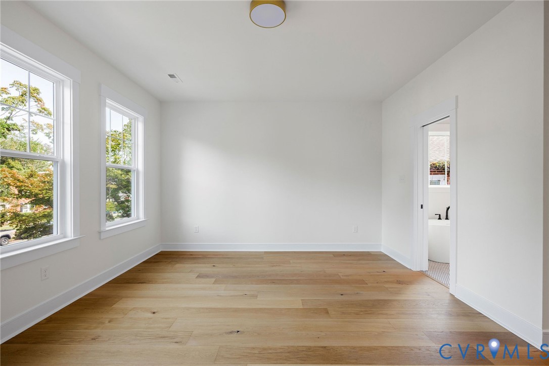 3423 Stuart Avenue Richmond, VA 23221 - Photo 21 of 34 an empty room with wooden floor and windows