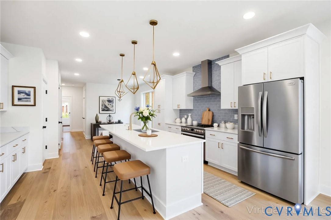 3423 Stuart Avenue Richmond, VA 23221 - Photo 10 of 34 a kitchen with stainless steel appliances a refrigerator a stove a sink a dining table and chairs