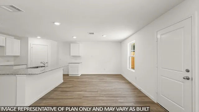 a view of a kitchen with kitchen island a sink dishwasher and a stove with wooden floor