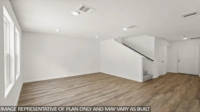 an empty room with wooden floor and entryway