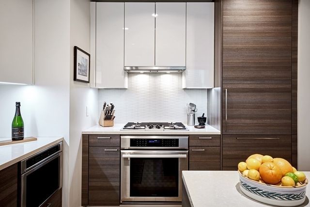a kitchen with stainless steel appliances granite countertop a stove a sink and a white cabinets