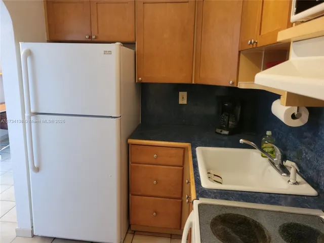 a living room with furniture a refrigerator and a table