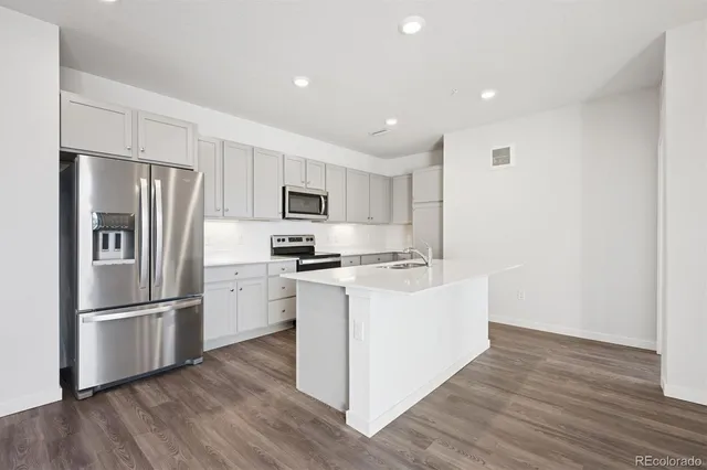 a kitchen with refrigerator cabinets and wooden floor