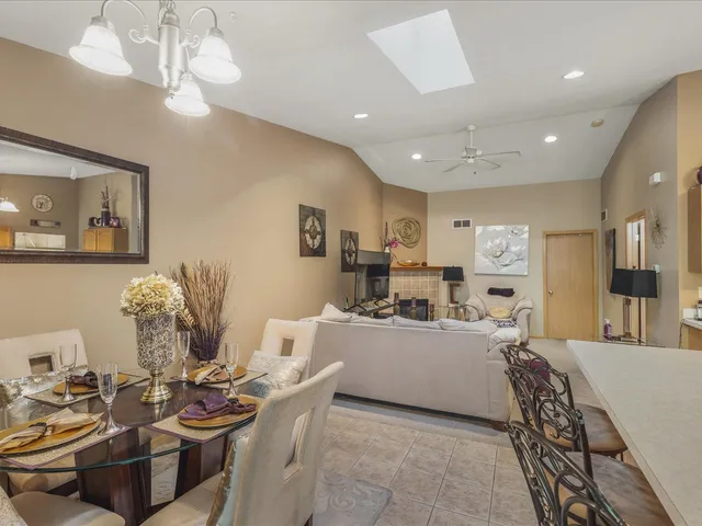 a very nice looking living room with stainless steel appliances kitchen island granite countertop furniture and a large window