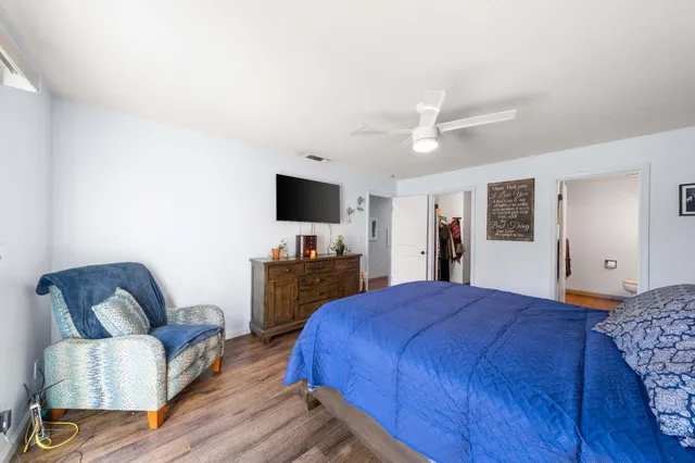 a bedroom with a bed a couch and a flat screen tv