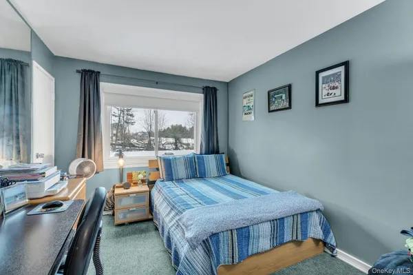 a bedroom with a bed and a large window