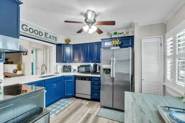 a kitchen with stainless steel appliances granite countertop a refrigerator a sink dishwasher a stove and a dining table with wooden floor