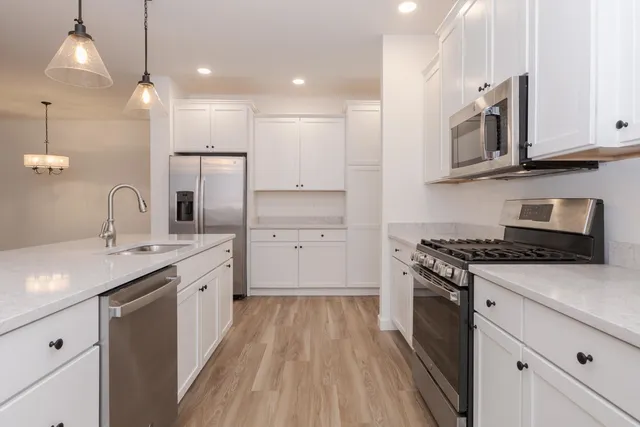 a kitchen with stainless steel appliances granite countertop a sink stove and cabinets
