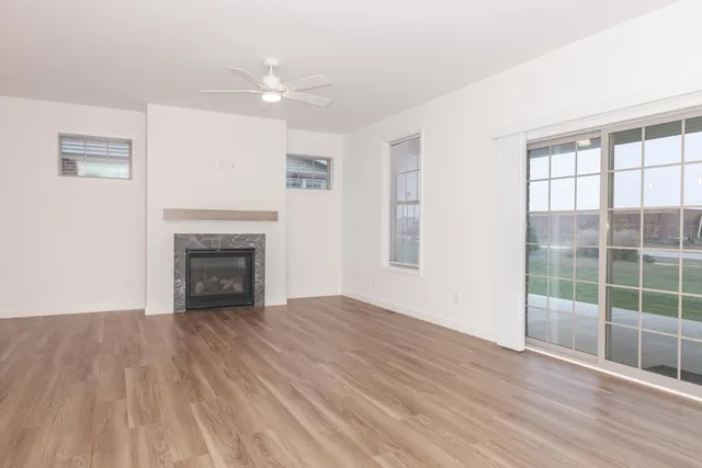 a view of empty room with wooden floor and fireplace