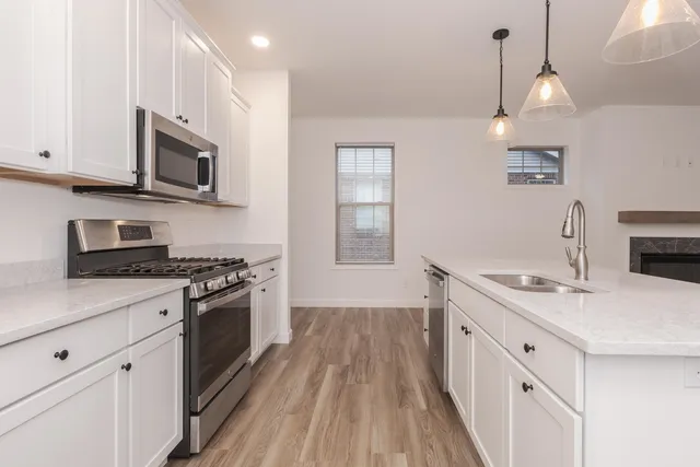 a kitchen with stainless steel appliances granite countertop a sink stove and microwave