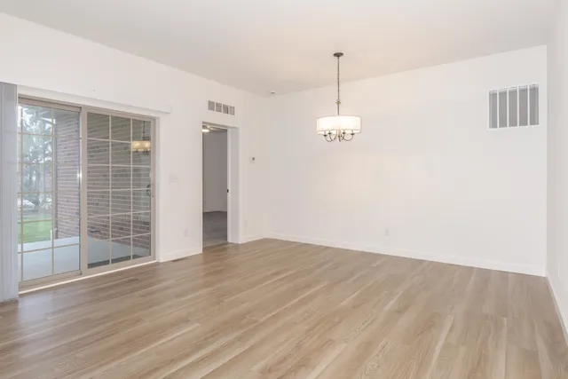 a view of a room with wooden floor and window