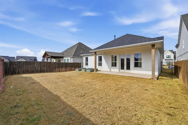 a view of a house with a patio and a yard