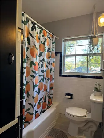 a bathroom with a toilet and a shower curtain