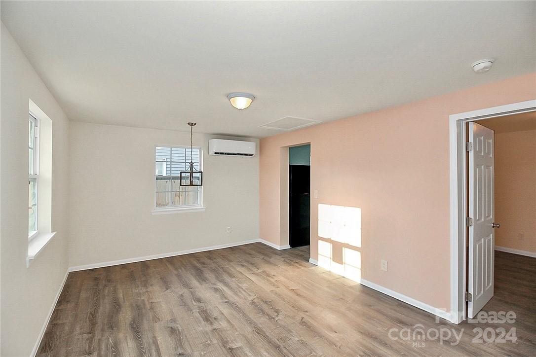 217 Sanders Street, Unit A Fort Mill, SC 29715 - Photo 2 of 16 an empty room with wooden floor and windows