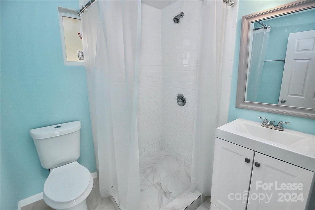 217 Sanders Street, Unit A Fort Mill, SC 29715 - Photo 5 of 16 a white toilet sitting next to a bathroom sink