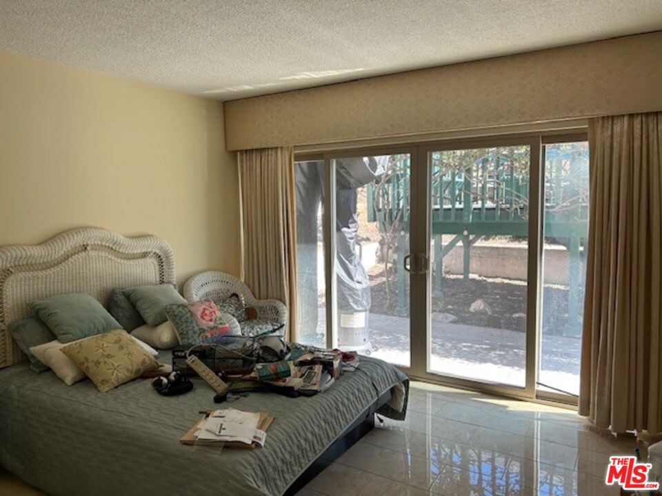 3908 Castlerock Road Malibu, CA 90265 - Photo 12 of 17 a bedroom with furniture and a large window
